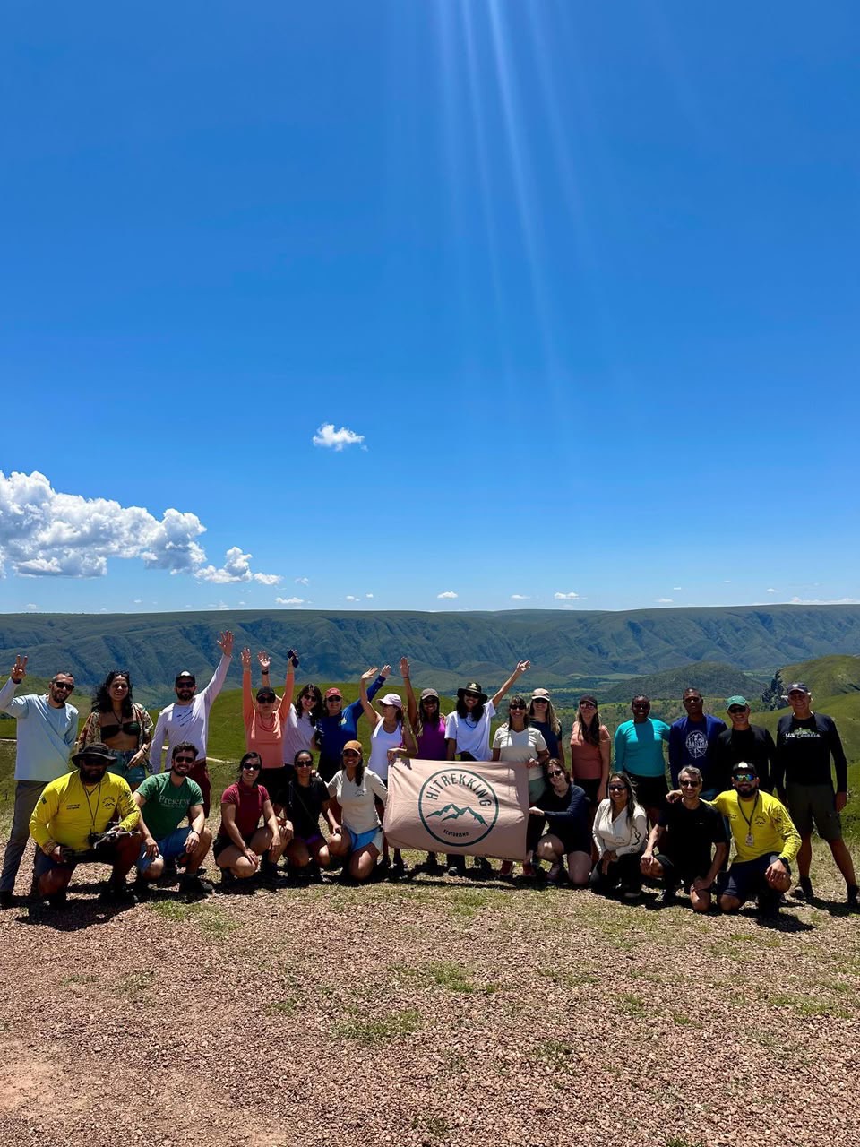 Grupo HiTrekking com a bandeira diante das serras