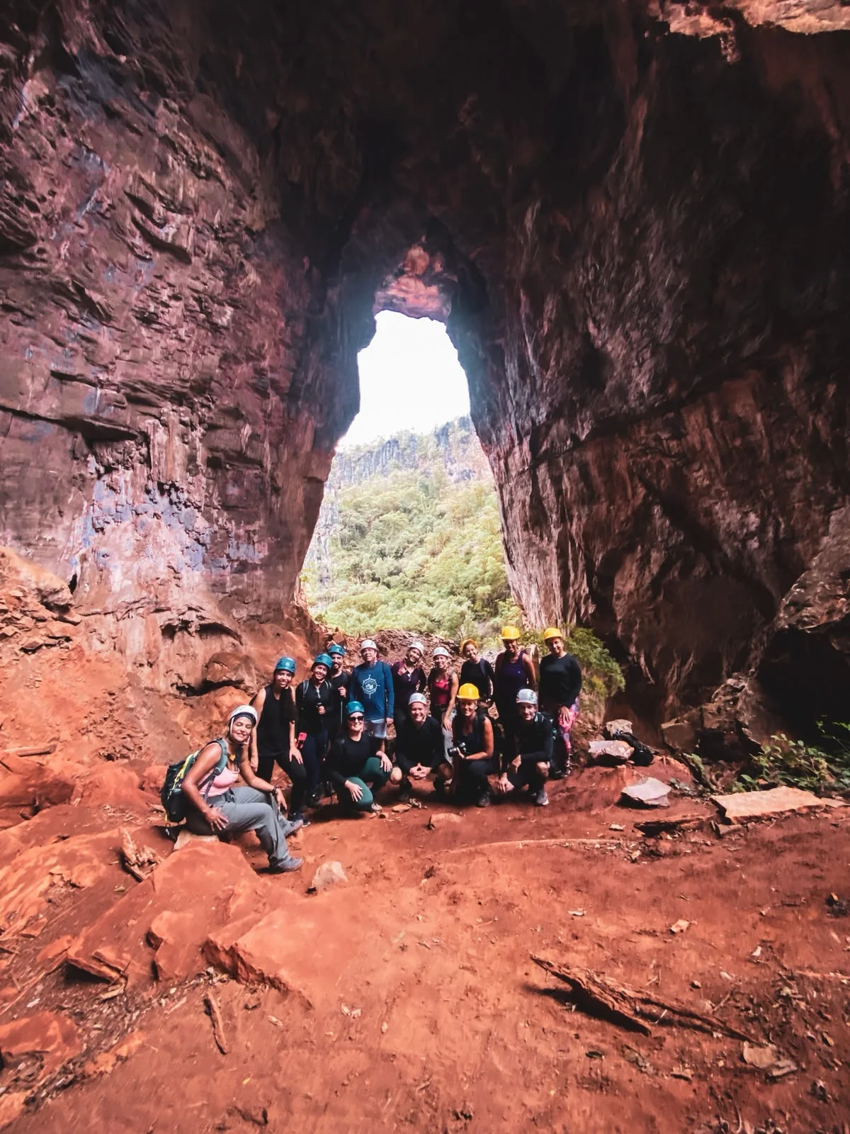 Grupo de viajantes reunido entre os grandes paredões de uma caverna