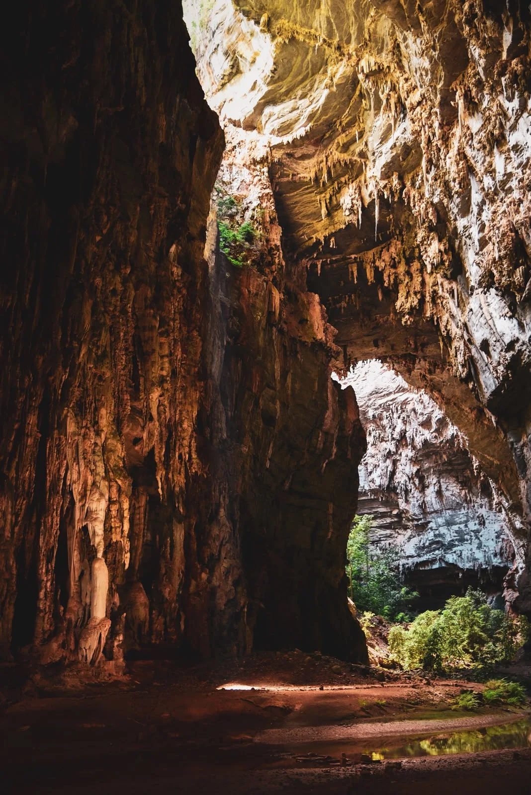 Salão de uma caverna com formações rochosas e iluminação natural