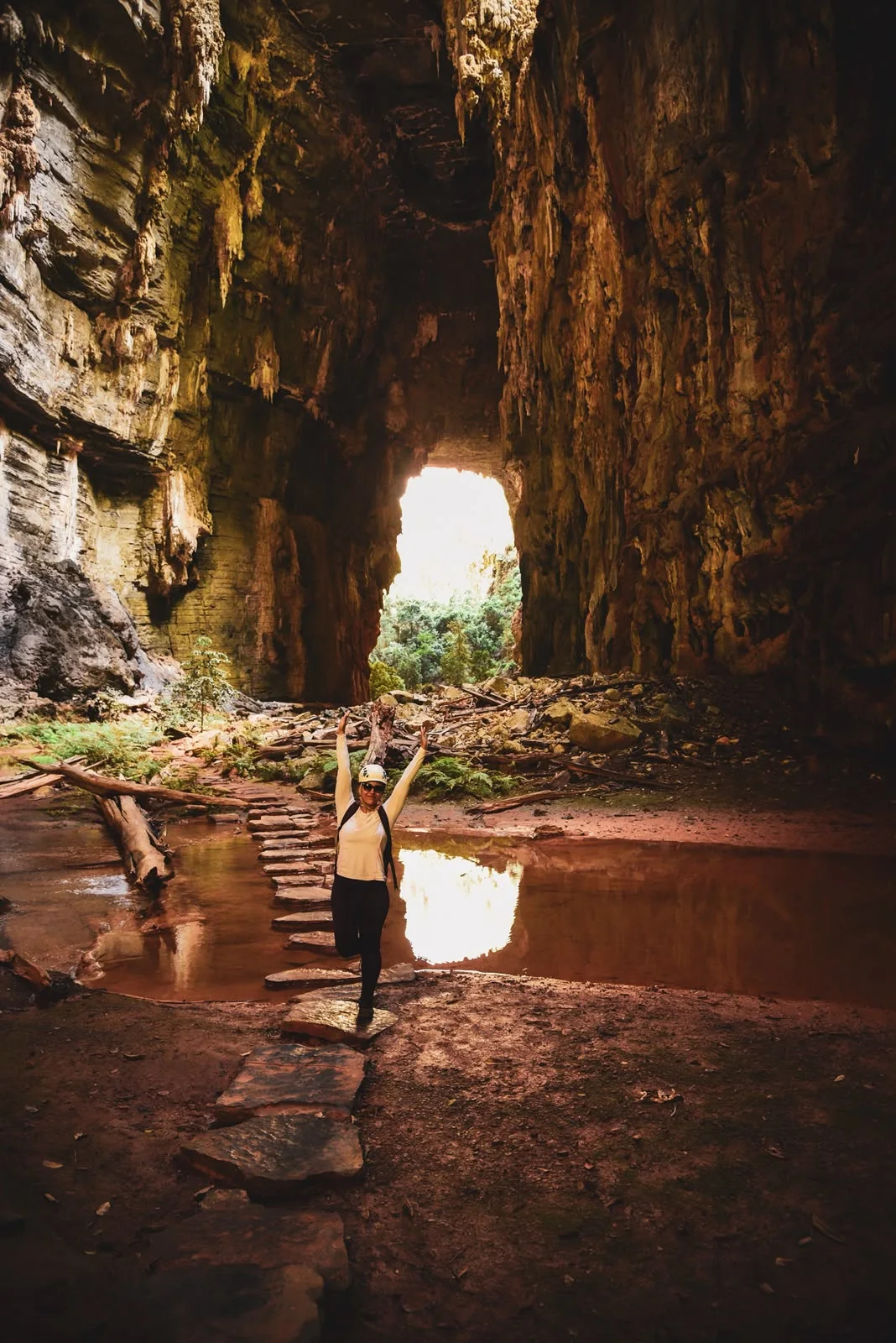 Viajante junto às pedras de uma travessia no interior da caverna
