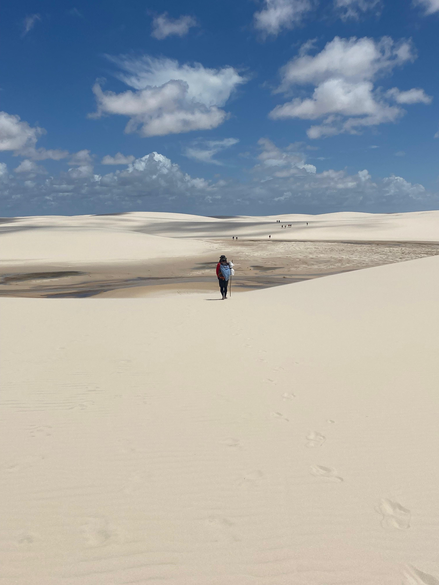 Caminhante entre dunas sob o céu azul