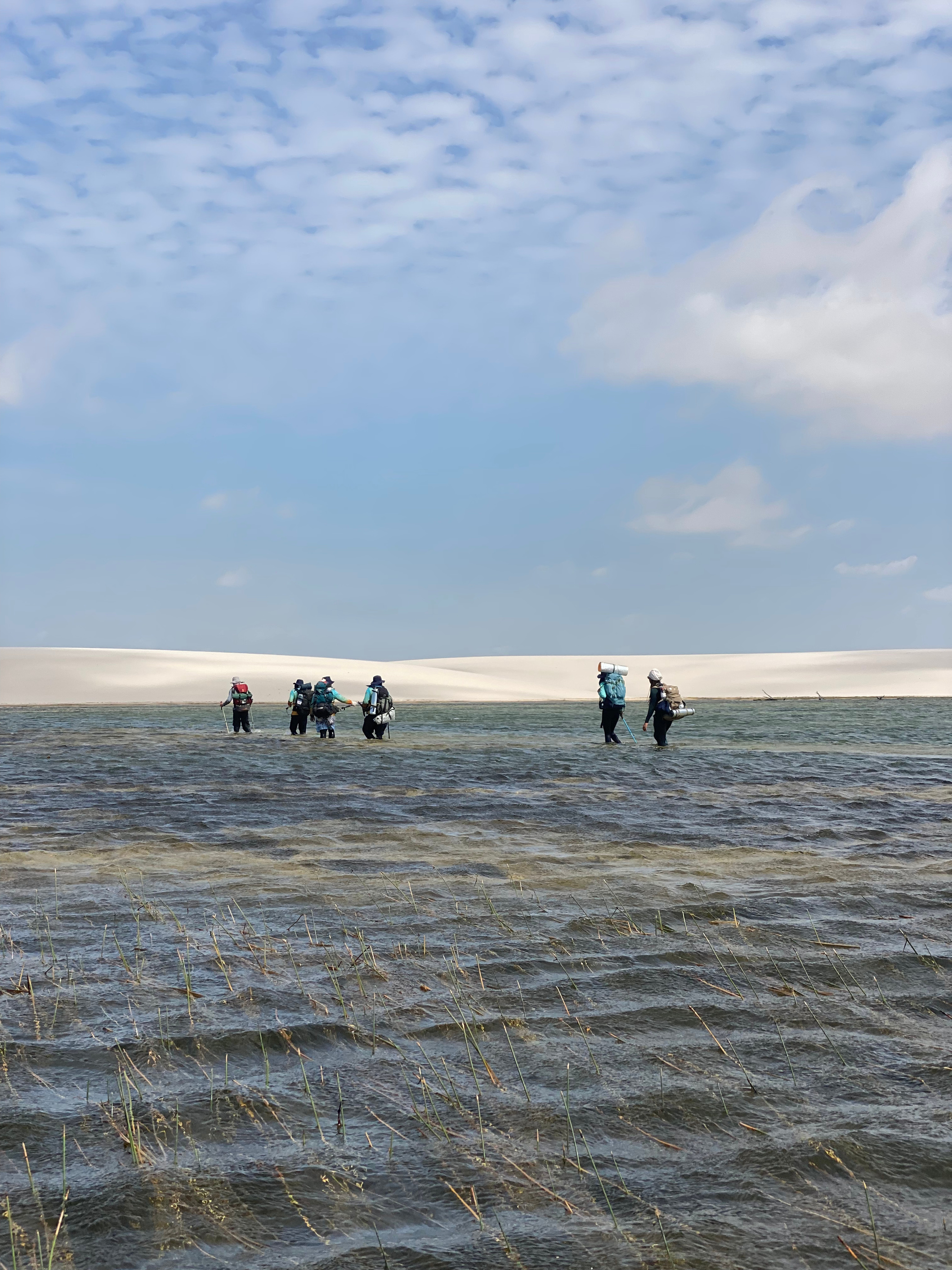 Grupo caminhando pelas águas de uma lagoa