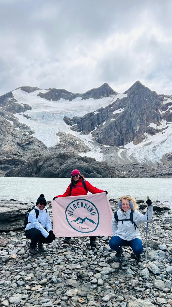 Nosso grupo com a bandeira HiTrekking diante de um lago e das montanhas da Patagônia