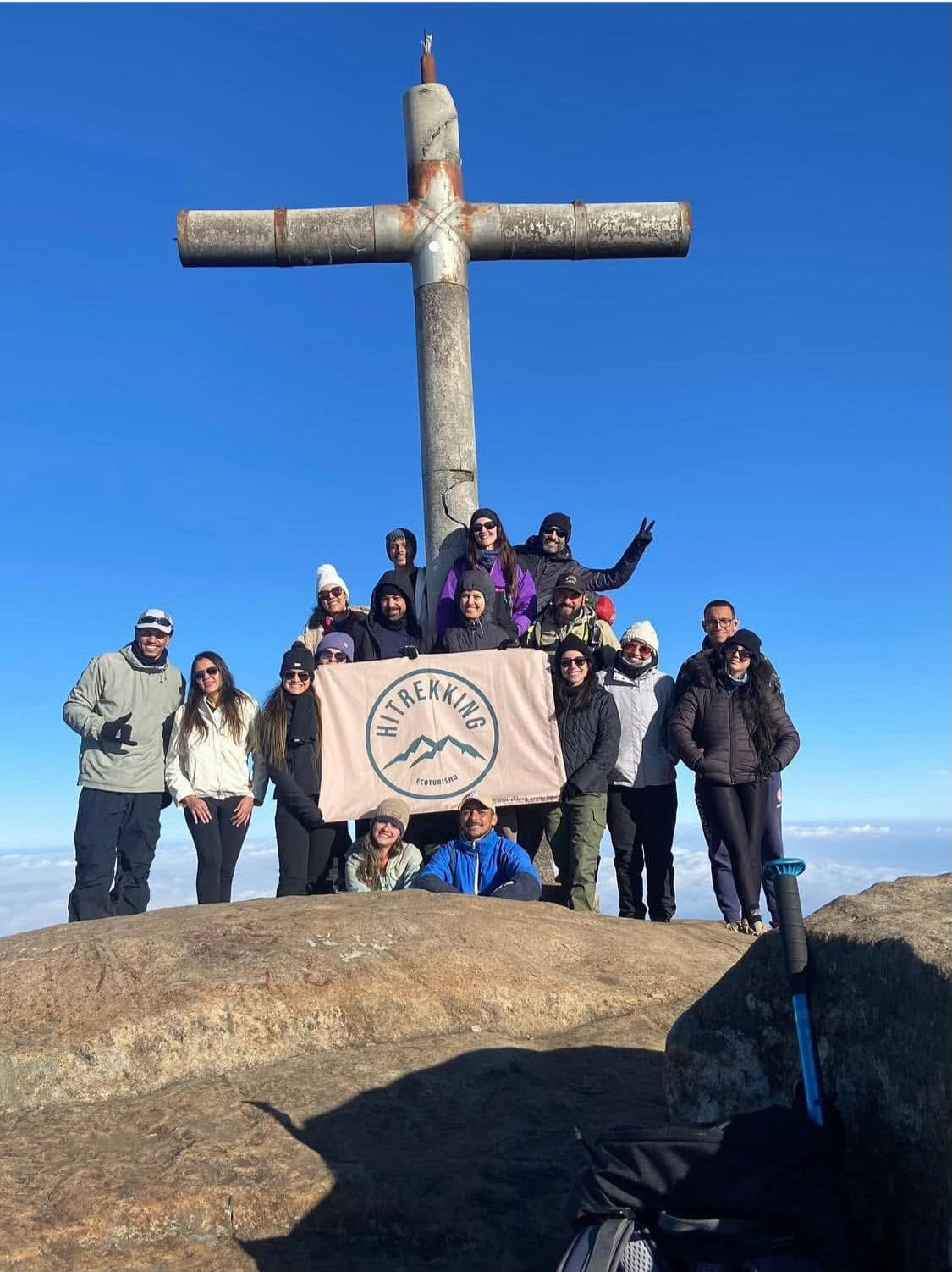 Grupo da HiTrekking com a bandeira no cume do Pico da Bandeira, junto à cruz
